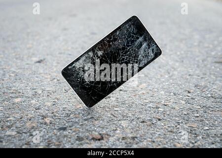 Kaputt, zerstört, ruiniert modernes Handy, Handy, Handy, Telefon. Kaputte, rissige Folie und Schäden. Gerät zerstört. Mobiltelefon Stockfoto