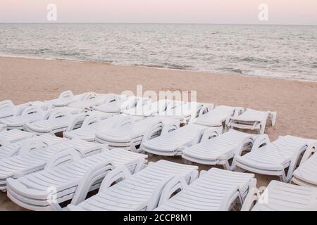 Am Strand gibt es abends viele Sonnenliegen Stockfoto