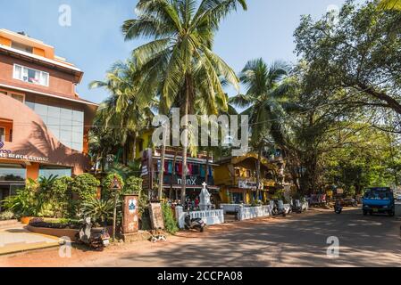 Candolim, North Goa, Indien - 23. November 2019: Straßenansicht von Goa an sonnigen Tag mit geparkten Fahrrädern in der Nähe von Touristenläden und Apotheke in Candolim, North G Stockfoto