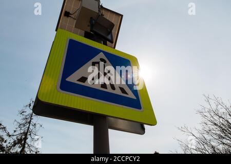 Das Fußgängerübergangsschild mit Solarpaneelen, die oben installiert sind. Verkehrszeichen und Regeln. Stockfoto