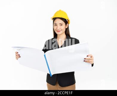 Junge asiatische Geschäftsfrau lächelnd trägt schwarzen Anzug und gelben Schutzhelm halten Projekt Engineering Papier Pläne. Portrait der Ingenieurin Toilette Stockfoto