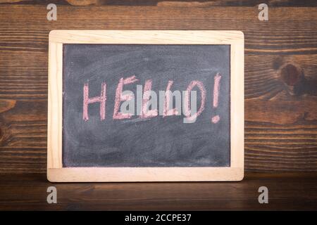 HALLO. Geschäftskonzept. Kreidetafel mit einer Inschrift auf einem hölzernen Hintergrund Stockfoto