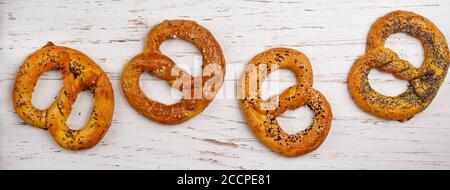 Brezel. Eine Reihe von verschiedenen Brezeln mit schwarzem und weißem Sesam, Mohn, Kümmel oder Kümmel, großes Meersalz. Süße und salzige Vorspeise für Feinschmecker Stockfoto