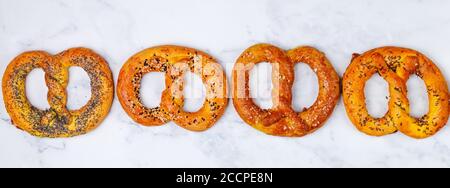 Brezel. Eine Reihe von verschiedenen Brezeln mit schwarzem und weißem Sesam, Mohn, Kümmel oder Kümmel, großes Meersalz. Süße und salzige Vorspeise für Feinschmecker Stockfoto