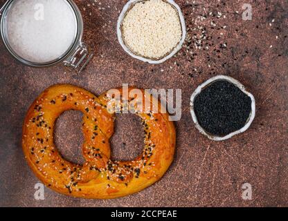 Frisch gebackenes hausgemachtes Pretzel mit schwarzem und weißem Sesam und grobem Meersalz. Deutscher (bayerischer) Biervorspeise. Selektiver Fokus Stockfoto