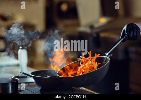 Moderne Küche. Köche bereiten Mahlzeiten auf dem Herd in der Küche des Restaurant oder Hotel. Das Feuer in der Küche. Stockfoto