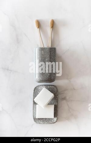 Komposition mit biologisch abbaubaren Bambuszahnbürsten und Naturseife auf Marmorboden. Nachhaltig, Null Abfall, plastikfrei, Lifestyle-Konzept. Flach liegend, Draufsicht. Stockfoto