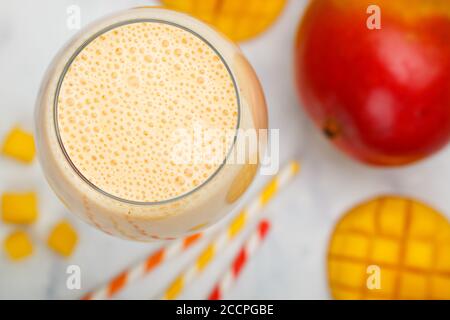 Smoothie oder Milchshake-Cocktail mit frischen Erdbeeren, Mango, Joghurt oder Milch und Eiswürfeln in einem Glas auf einem Marmortisch. Konzept des gesunden Vitamin d Stockfoto