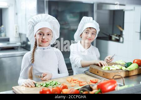 Kinder mahlen Gemüse in der Küche eines Restaurants. Stockfoto