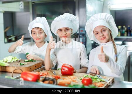 Kinder mahlen Gemüse in der Küche eines Restaurants. Stockfoto