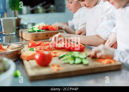 Kinder mahlen Gemüse in der Küche eines Restaurants. Stockfoto