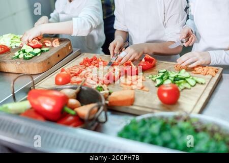 Kinder mahlen Gemüse in der Küche eines Restaurants. Stockfoto