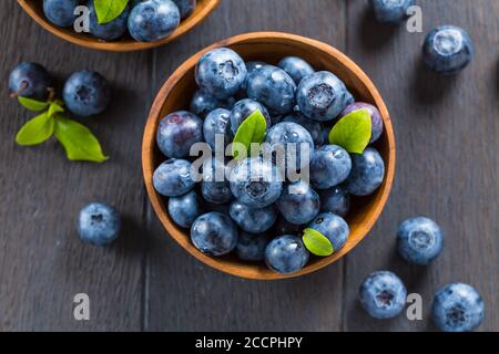 Frische Bio-Heidelbeere in Schale auf Holzhintergrund. Gesunde Ernährung Konzept, saftige Waldbeeren. Stockfoto