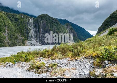 Die Berge ragen über dem Tal des Franz-Josef-Gletschers an der Westküste Neuseelands. Gemäßigte Regenwälder wachsen überall, wo sie können und die dunklen c Stockfoto