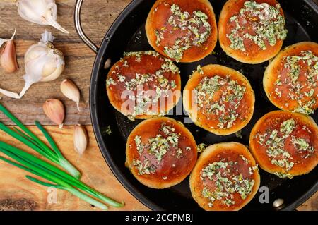 Pampushky. Traditionelle ukrainische hausgemachte Brötchen (Brot) mit Knoblauch, Kräutern und Öl. Serviert mit Borscht. Selektiver Fokus, Draufsicht Stockfoto