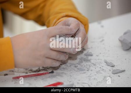 Bild eines Lernspiels, um Fossilien für einen kleinen Archäologen zu finden, mit Kindern Hände graben Stockfoto