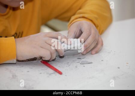 Bild eines Lernspiels, um Fossilien für einen kleinen Archäologen zu finden, mit Kindern Hände graben Stockfoto