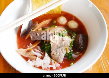 Nudeln mit Meeresfrüchten auf roter Suppe / scharf und würzig thai Essen Nudel Tintenfisch Schweinefleisch Fisch Ball Morgen Ruhm knusprig Wontonhaut Schweinefleisch und Blutwürfel Stockfoto