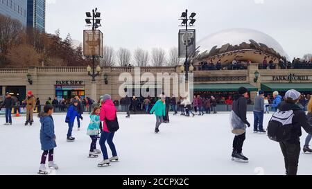 Eisläufer auf der Millennium Park Ice Rink mit der Cloud Gate Skulptur im Hintergrund, Chicago Illinois, USA Stockfoto