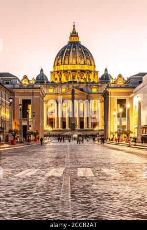 Vatikanstadt bei Nacht. Beleuchtete Kuppel der Petersbasilika und des Petersplatzes am Ende der Via della Conciliazione. Rom, Italien. Stockfoto