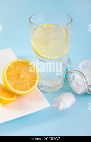 Backpulver in Trinkglas mit Wasser und Zitronensaft, gesundheitliche Vorteile für das Verdauungssystem Konzept. Hellblauer Hintergrund. Stockfoto