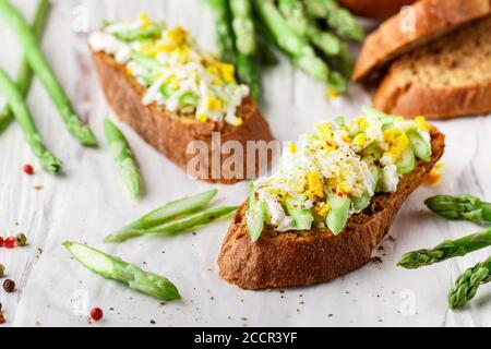 Roggenbrot-Sandwich mit Spargel, Feta-Käse und Ei. Leckeres und gesundes Frühstück. Bruschetta. Rustikaler Stil. Selektiver Fokus Stockfoto