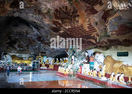 Zwei große Figuren eines liegenden Buddha. Tempel in einer Höhle, alte Figuren auf den felsigen Wänden geschnitzt. Hpa An, Myanmar, Burma, Südostasien Stockfoto