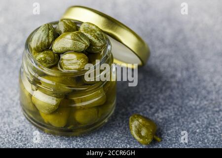 Eingelegte oder gesalzene Kapern in einem Glas Nahaufnahme. Ungeöffnete Blütenknospen. Köstliche Zutaten für die Zubereitung mediterraner, italienischer, spanischer, französischer Cuis Stockfoto