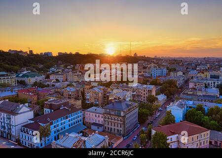 Sonnenuntergang über der Altstadt von Kiew - Podil, Dächer Blick auf alte Häuser vor der Kulisse des Sonnenuntergangs am Wochenende. Lufttrohnenaufnahme. Stockfoto