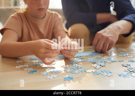 Warm getönte Nahaufnahme von unkenntlich Mädchen spielen Brettspiele mit Großeltern, während genießen Zeit zusammen, kopieren Raum Stockfoto