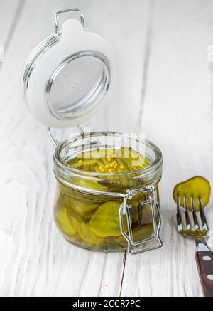Scheiben eingelegte Gurken mit Senf in einem Glas. Vorspeise für Feinschmecker. Eine Zutat für die Zubereitung von Sandwiches und Salaten. Selektiver Fokus, Kopierbereich Stockfoto