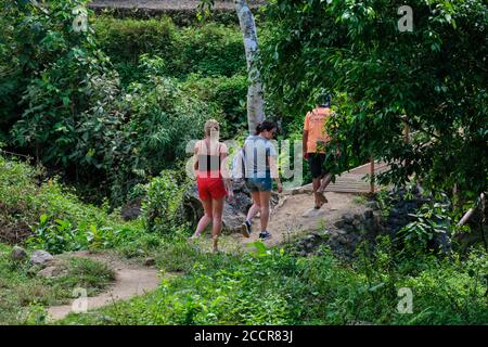 Panay, Philippinen - 24. Jan 2020: Touristen wandern auf einem Pfad durch den philippinischen Wald auf der Insel Panay. Stockfoto