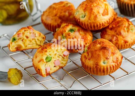 Köstliche frisch gebackene hausgemachte herzhafte Muffins mit Parmesan-Käse, Wurst oder Schinken und grünen Erbsen. Gourmet-Vorspeise. Selektiver Fokus Stockfoto