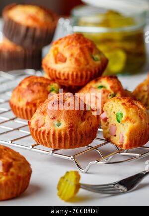 Köstliche frisch gebackene hausgemachte herzhafte Muffins mit Parmesan-Käse, Wurst oder Schinken und grünen Erbsen. Gourmet-Vorspeise. Selektiver Fokus Stockfoto