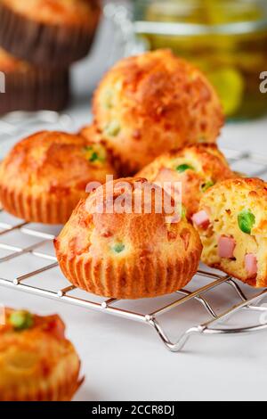 Köstliche frisch gebackene hausgemachte herzhafte Muffins mit Parmesan-Käse, Wurst oder Schinken und grünen Erbsen. Gourmet-Vorspeise. Selektiver Fokus Stockfoto