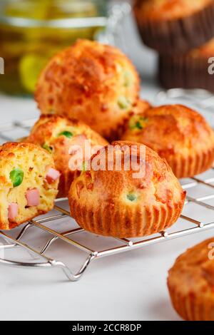 Köstliche frisch gebackene hausgemachte herzhafte Muffins mit Parmesan-Käse, Wurst oder Schinken und grünen Erbsen. Gourmet-Vorspeise. Selektiver Fokus Stockfoto