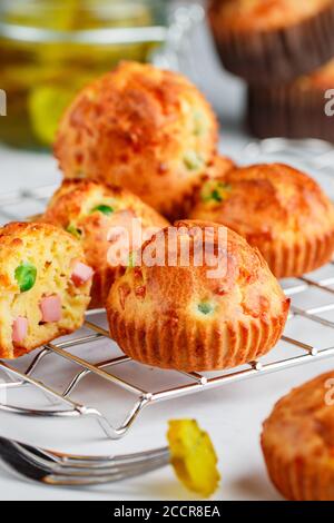 Köstliche frisch gebackene hausgemachte herzhafte Muffins mit Parmesan-Käse, Wurst oder Schinken und grünen Erbsen. Gourmet-Vorspeise. Selektiver Fokus Stockfoto