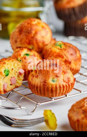 Köstliche frisch gebackene hausgemachte herzhafte Muffins mit Parmesan-Käse, Wurst oder Schinken und grünen Erbsen. Gourmet-Vorspeise. Selektiver Fokus Stockfoto