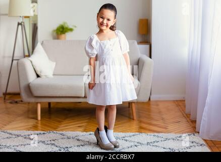 Liebenswert asiatische Mädchen tragen Mutter High Heels Schuhe im Innen Stockfoto