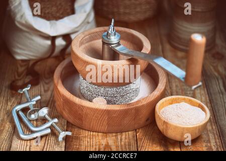 Getreidemühle - Manuelle Getreidemühle zum Handschleifen, auf einem Holztisch Stockfoto
