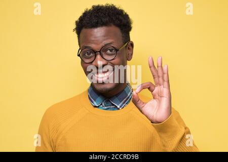 Erfolgreicher aufgeregt junger afrikanischer Mann zeigt ok Zeichen Stockfoto