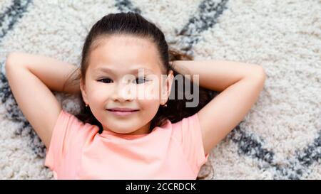 Asiatisch Kind Mädchen Posiert Liegend Auf Boden Bei Zuhause, Panorama Stockfoto