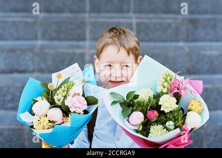 Blumenstrauß für den ersten geliebten Lehrer am ersten September. Blumen für die letzte Glocke. Tag des Wissens. Beginn des Schuljahres. Erstklässler mit Blumenstrauß in Stockfoto