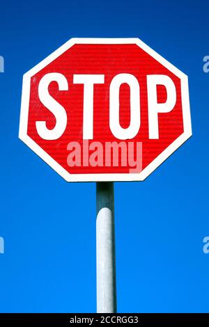 Rotes Stoppschild, das ein Stoppschild ist, mit dem der Verkehr angehalten wird Ein klares Bild mit blauem Himmel im Hintergrund Stockfoto