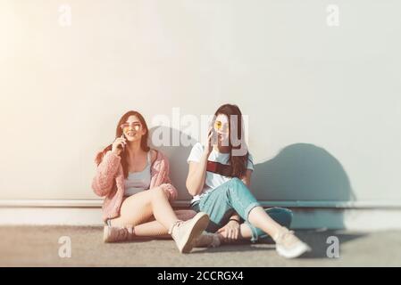 Zwei junge Frauen sprechen auf dem Handy Stockfoto