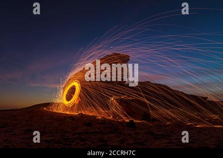 Nachts brennende Stahlwolle (Nachtaufnahmen mit langsamer Verschlusszeit) – selektiv auf das Motiv fokussiert. Stockfoto