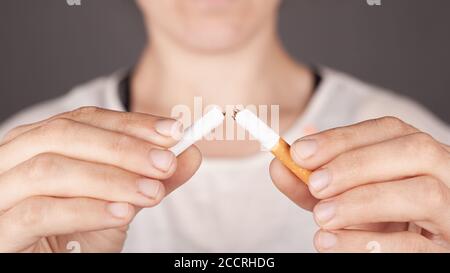 Mädchen hält eine zerbrochene Zigarette in der Hälfte Nahaufnahme, Schaden durch Rauchen, Rauchverbot Konzept, schlechte Angewohnheit, Schaden durch Nikotin. Stockfoto