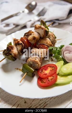 Vertikale Ansicht von Fleischkebabs auf einem weißen Teller Stockfoto