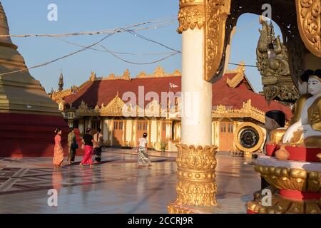 Buddhistische Frauen, die in der U Zina Pagode spazieren. Abend, Sonnenuntergang. Sie tragen traditionelles longyi und langes dunkles Haar. Mawlamyine, Myanmar, Burma, So Stockfoto