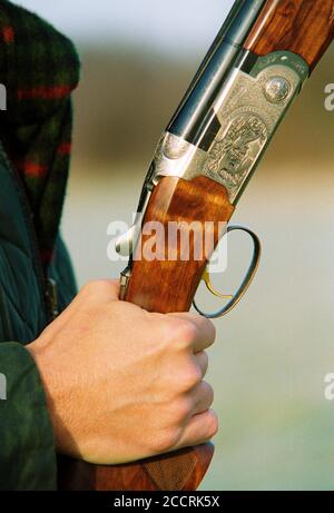 Nahaufnahme einer Hand, die eine Beretta-Schrotflinte nebeneinander hält. Großbritannien um 2001. Stockfoto